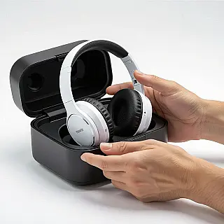 Draadloze hoofdtelefoon, uitpakfotografie, witte studiobackground achtergrond, zachte natuurlijke verlichting verlichting, opgewonden sfeer sfeer, close-up perspectief perspectief, promotiebanner ontwerp, handen die met product interageren, verpakkingselementen, commerciële esthetiek, authentiek moment, scherpe focus, lifestyle context